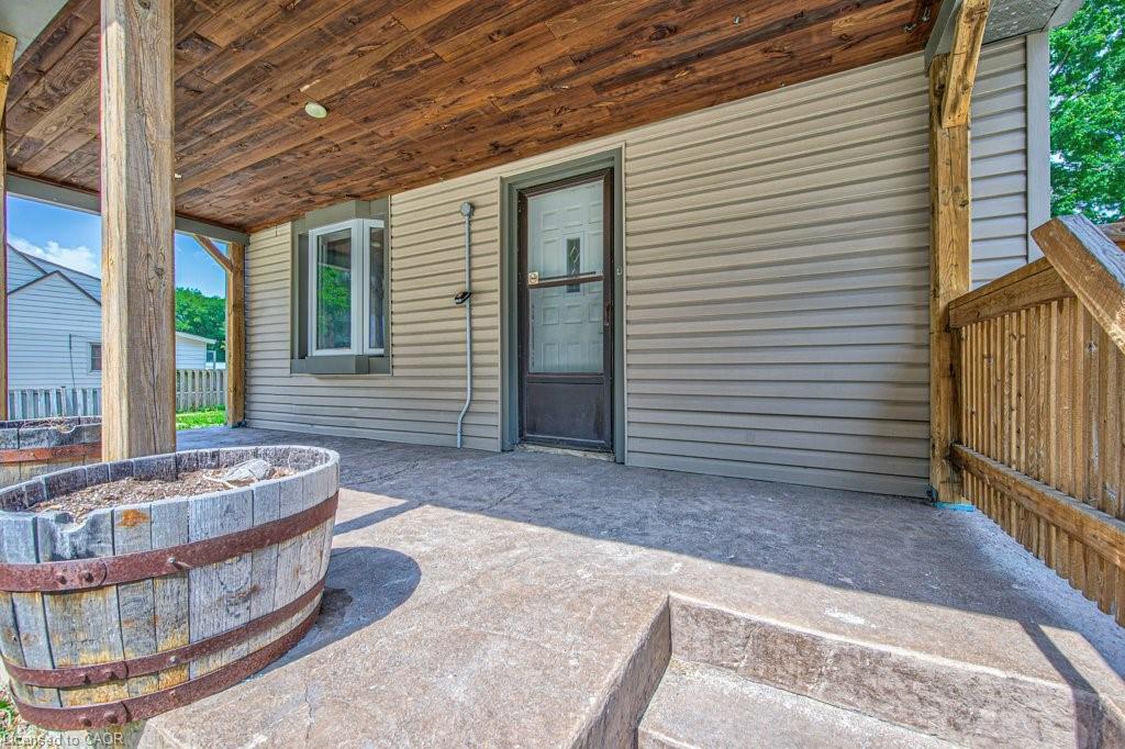 Covered porch featuring a wood-plank ceiling, stamped concrete flooring, bay window, and light-toned siding