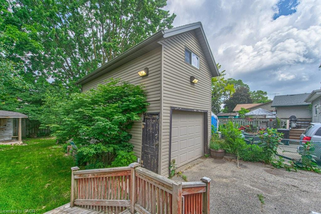 Detached two-story garage with horizontal siding and an overhead garage door