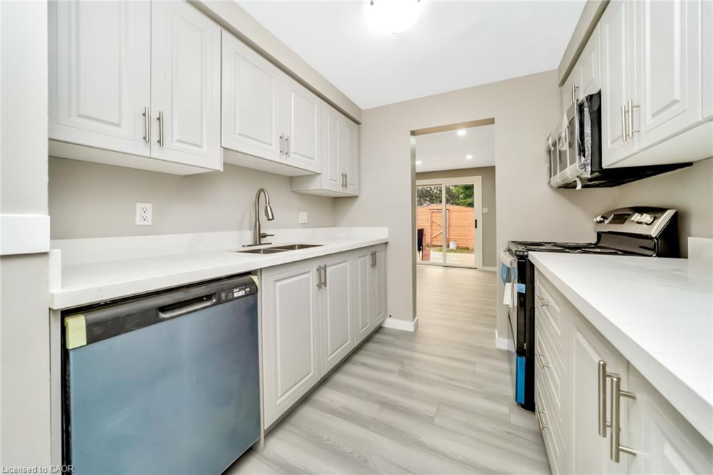 Modern kitchen featuring light gray cabinetry, white countertops, wood-finish flooring, a stainless steel sink with a gooseneck faucet, and a built-in dishwasher