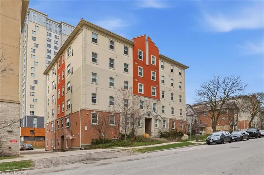Multi-story building featuring a brick base and stucco facade with a prominent red architectural accent
