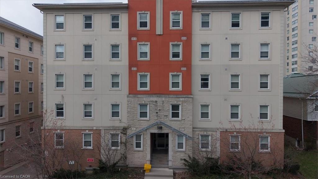 Multi-story building featuring a brick base, stone facade, and stucco exterior with contrasting red and beige sections