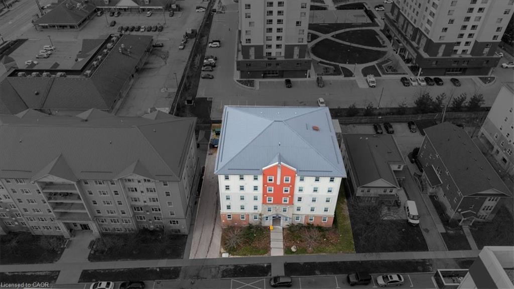 Multi-story building featuring a light blue hip roof, a prominent red central facade, and multiple windows