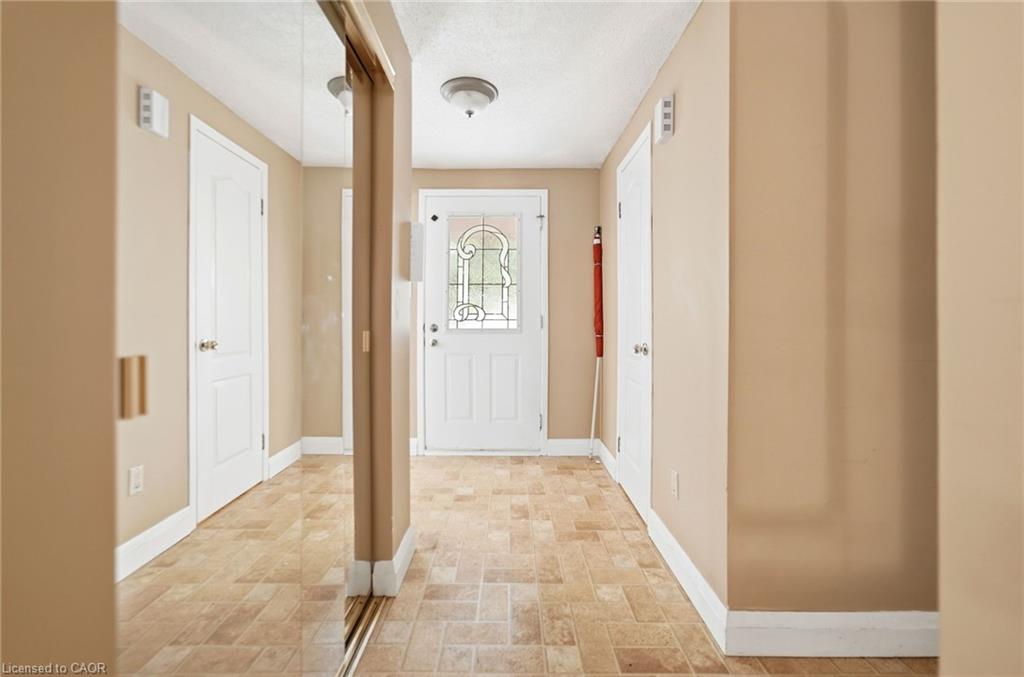 Entryway featuring a decorative glass paneled front door, neutral wall tones, and tiled flooring