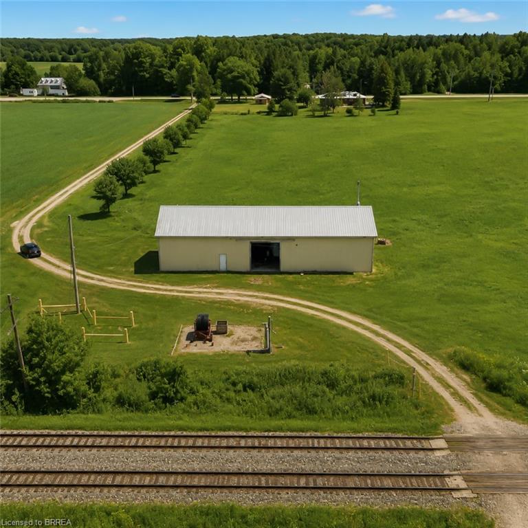 Large agricultural building featuring a metal roof and open bay door