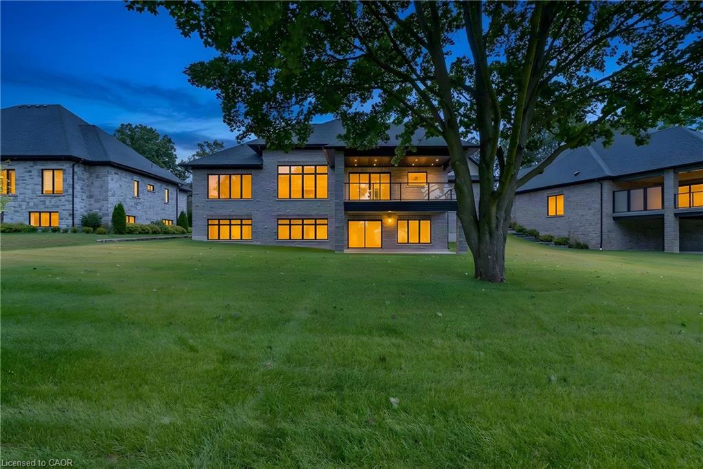 Expansive lawn with mature trees and stone-faced exterior