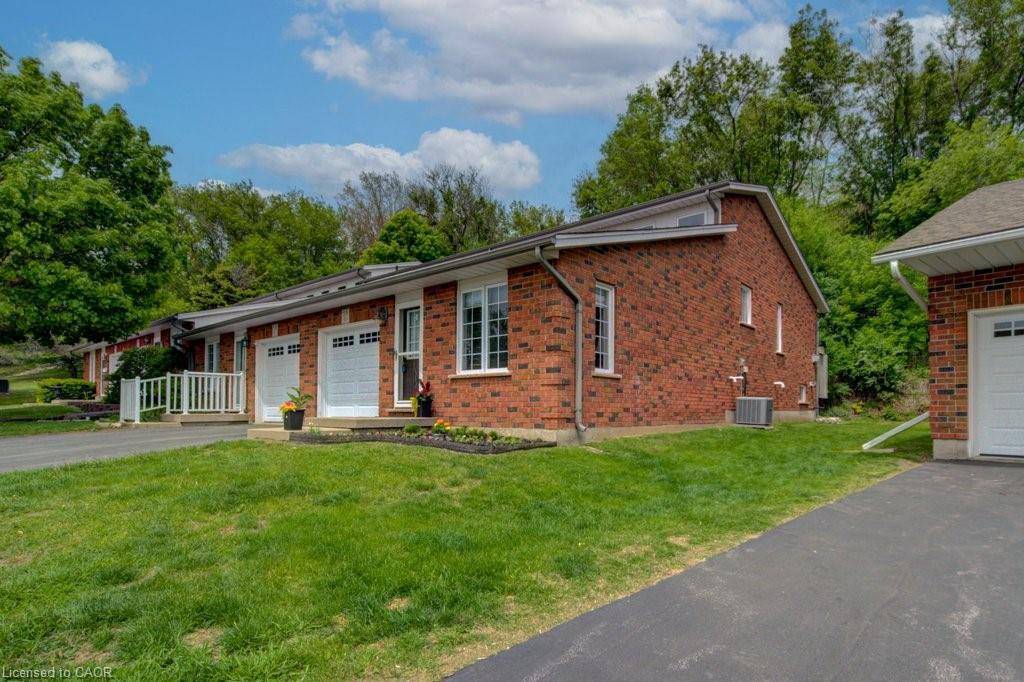 Brick exterior with white garage doors and white-framed windows