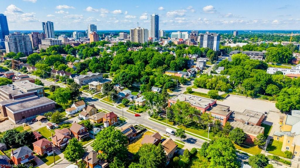 Aerial perspective showcasing a vibrant urban landscape with diverse architectural styles, a grid of residential streets, and abundant mature trees