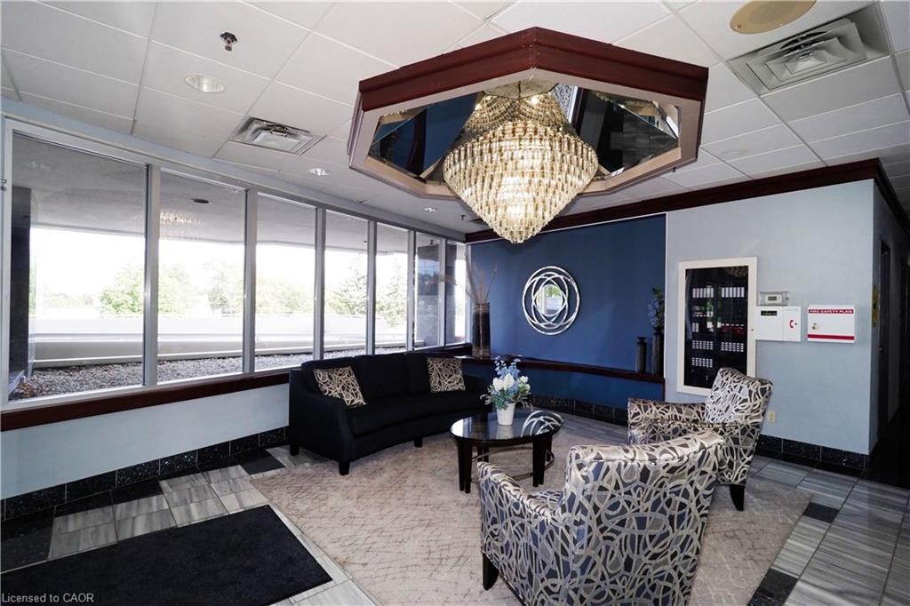 Lobby area featuring a large central chandelier with mirrored accents, floor-to-ceiling windows, and a tiled entry