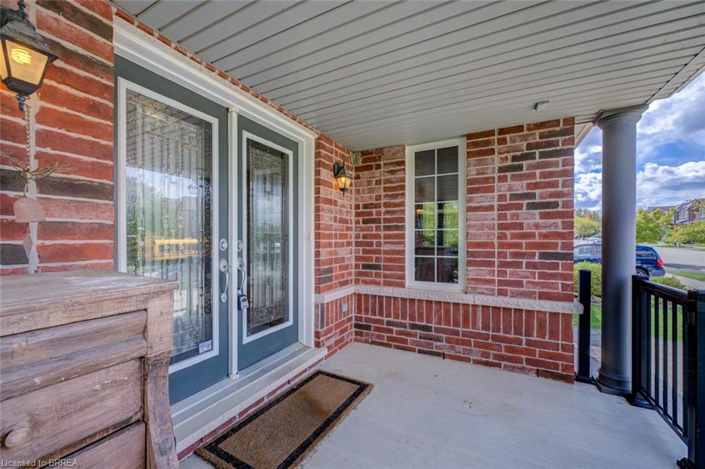 Brick exterior with stone accents, dual entry doors, decorative lighting fixtures, and a covered porch