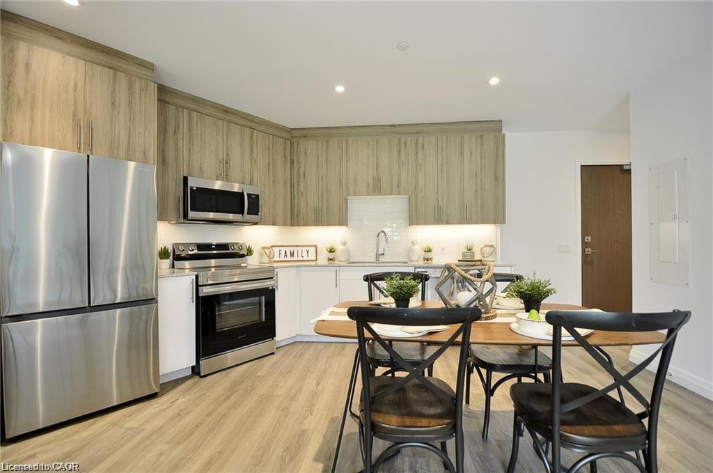 Contemporary kitchen featuring stainless steel appliances, wood-finish cabinetry, under-cabinet lighting, and a subway tile backsplash