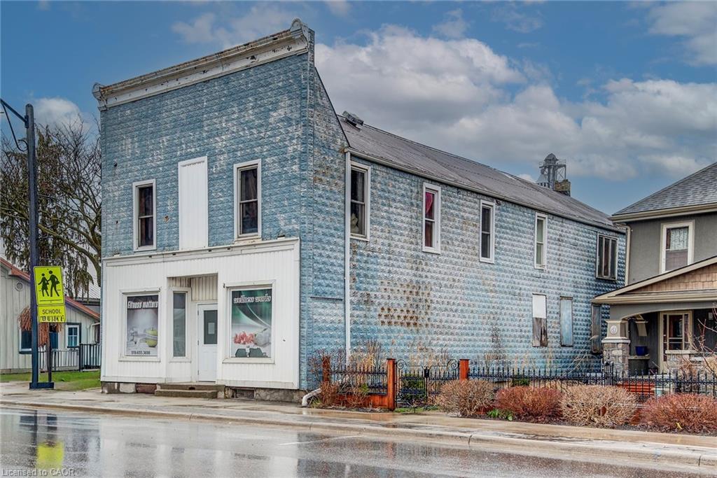 This property features a distinct two-story facade with a white lower level and a blue patterned upper level