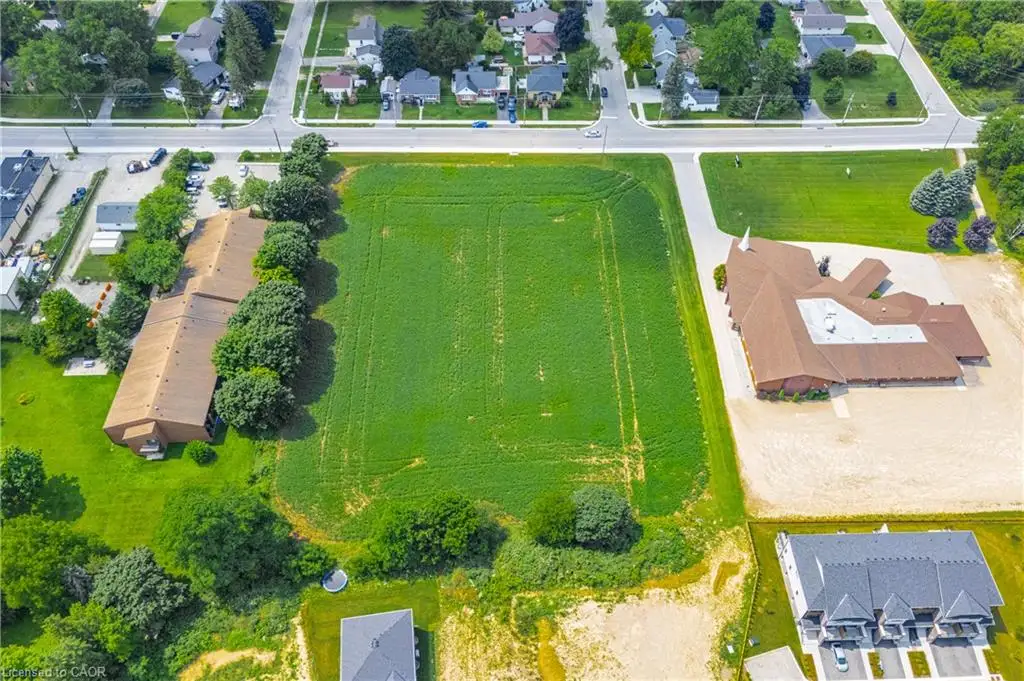 Expansive undeveloped land parcel with surrounding residential and commercial structures