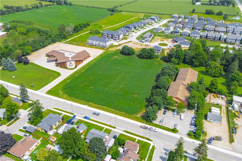 Expansive green field surrounded by established residential areas and commercial structures