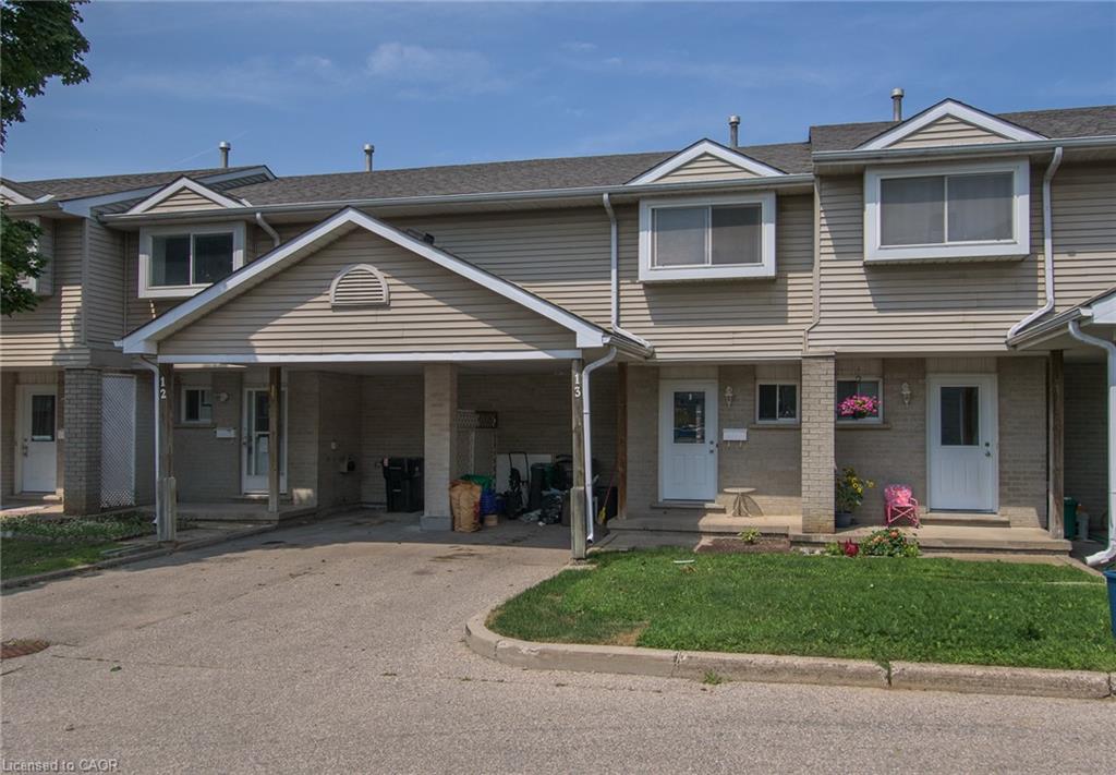 Attached townhouse units featuring light-toned siding and a shared paved driveway
