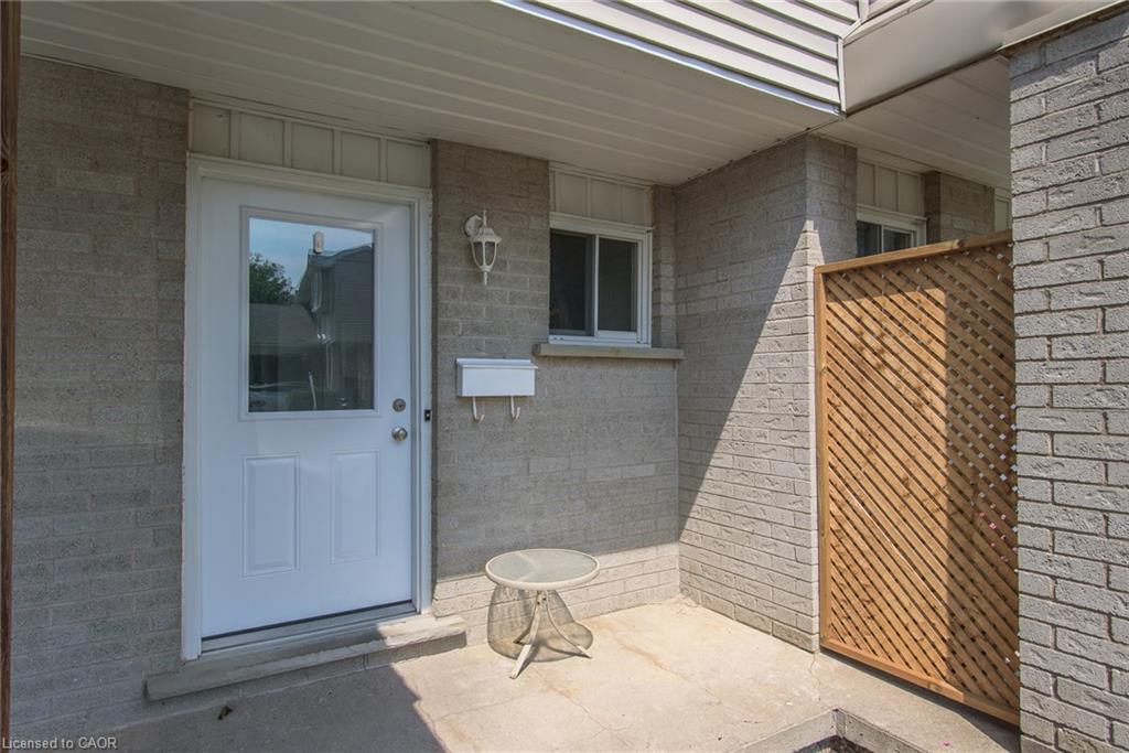 Brick exterior with a white entry door featuring a transom window