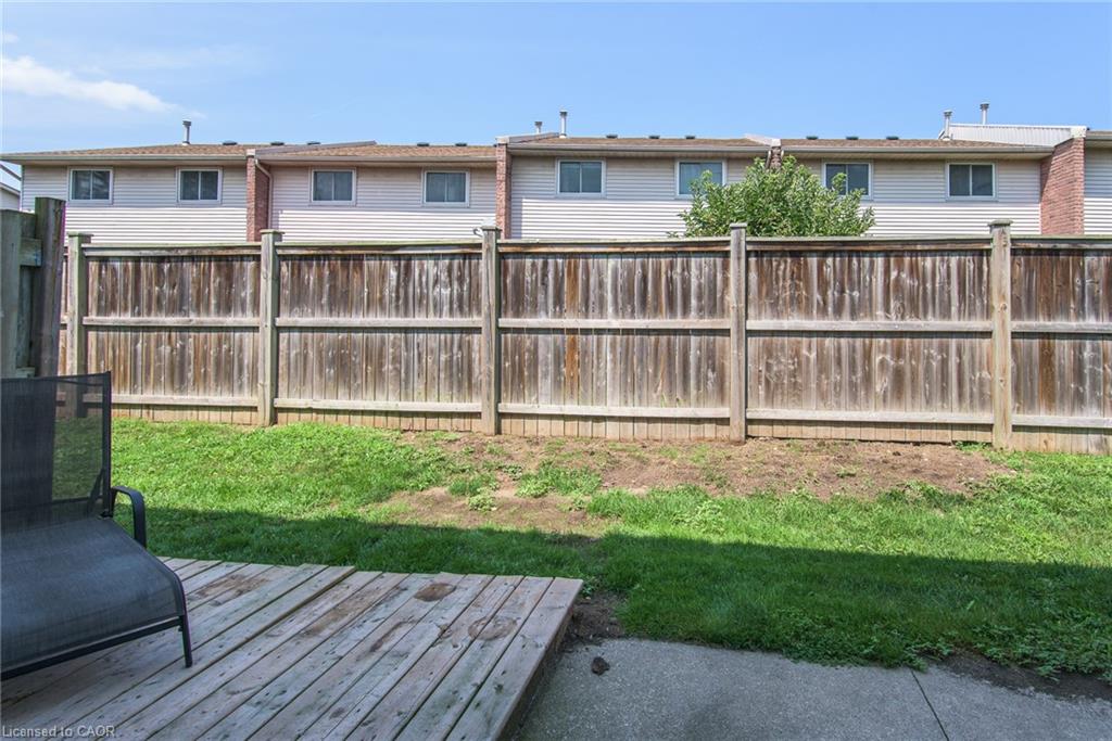 Private backyard featuring a wooden fence, a grass area, and a concrete patio
