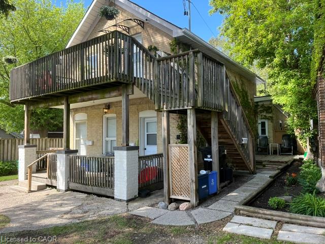 Brick exterior with two-story wooden deck, covered porch, and exterior staircase