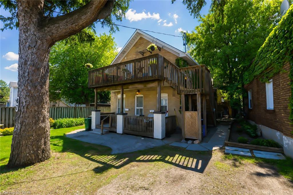 Two-story exterior with a second-level wood deck, a ground-level covered porch, and a gravel driveway