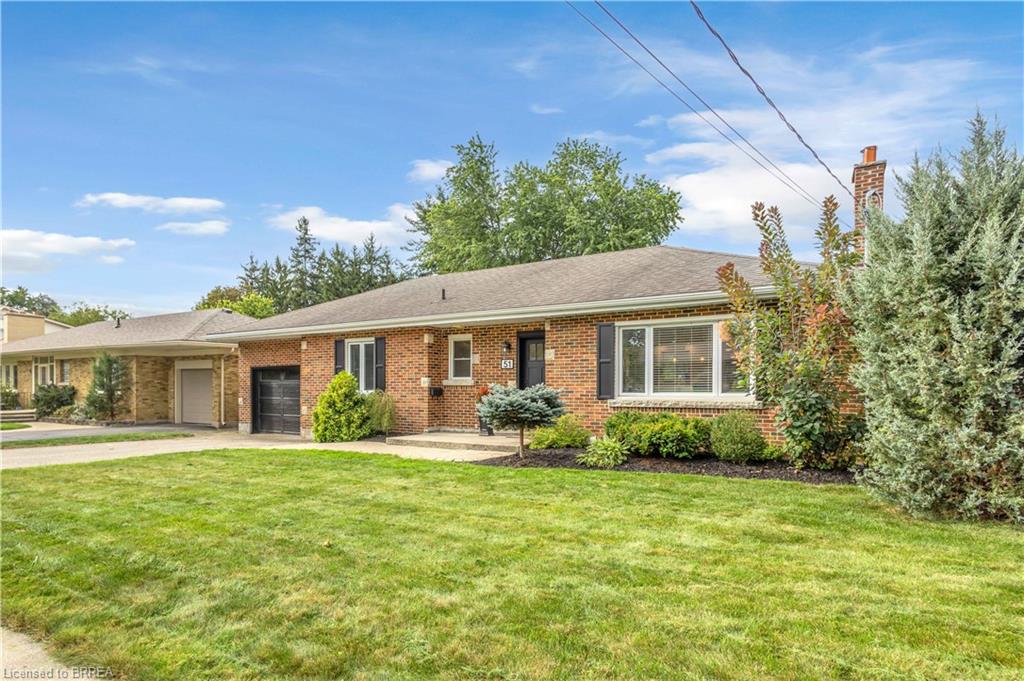 Brick exterior with a gabled roof, attached garage, and a covered carport