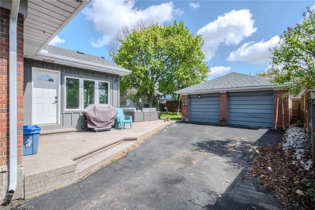 Paved driveway leading to a two-car brick garage with panel garage doors