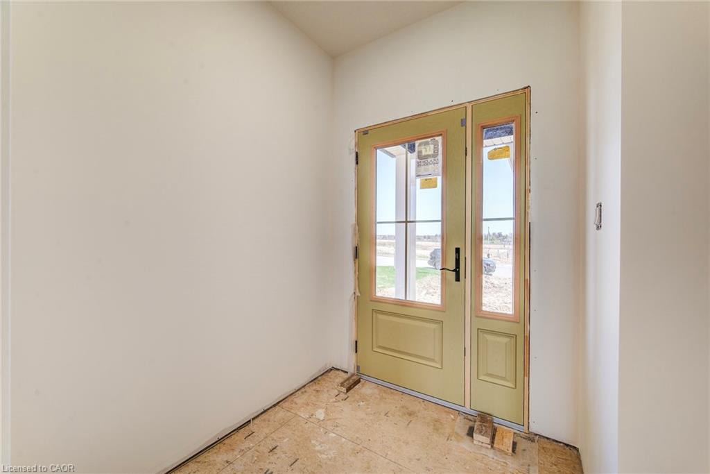 Entryway featuring a single-panel door with glass inserts and an adjacent fixed glass panel, light-colored walls, and subflooring