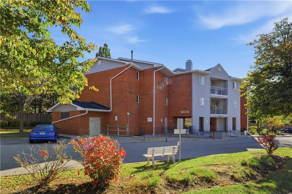 Multi-story brick exterior building featuring private balconies, gable rooflines, and paved surface parking