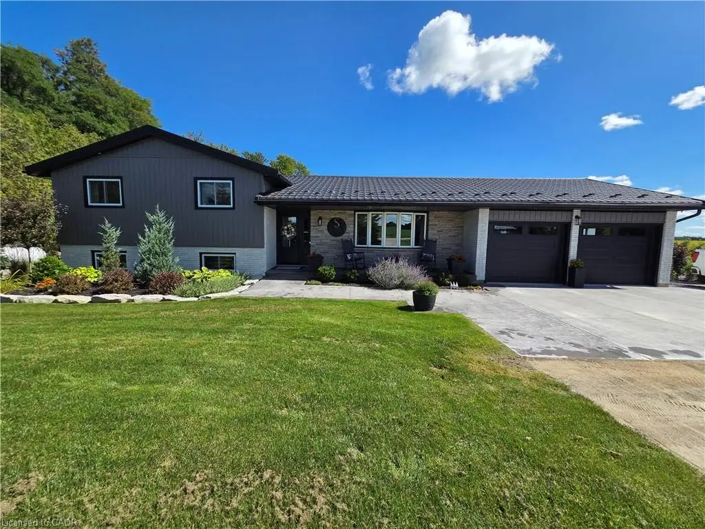 Contemporary exterior with dark siding, stone accents, and a metal roof