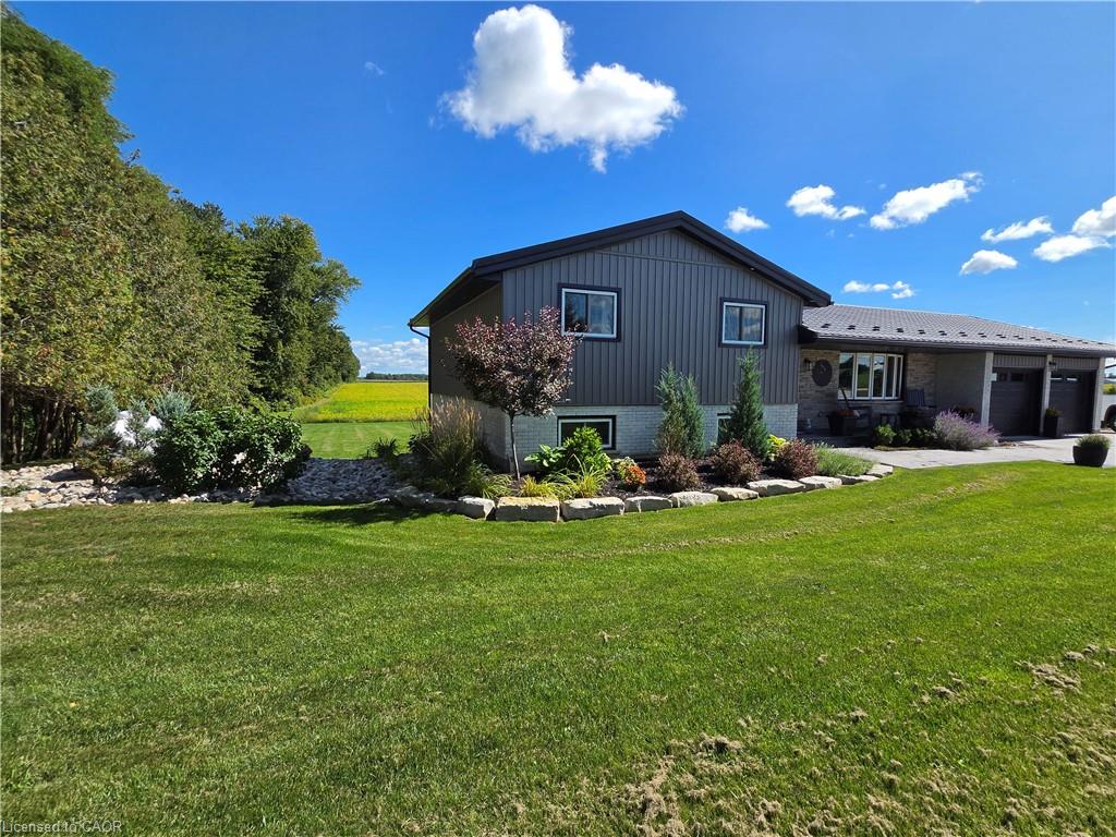 Two-story home with a dark gray vertical siding exterior and stone accents