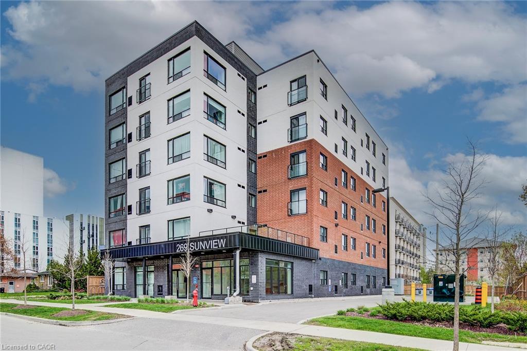 Contemporary multi-story building featuring a brick and panel facade, large windows, and ground-level commercial spaces