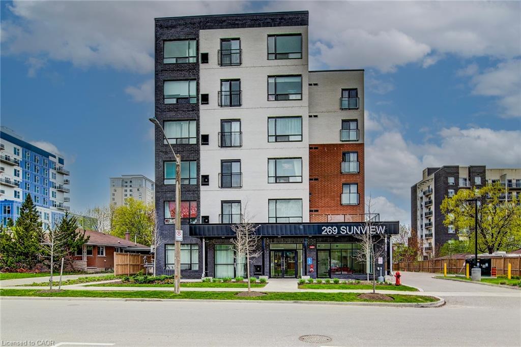 Contemporary multi-story building featuring a facade of dark brick, light-colored panels, and accent brickwork